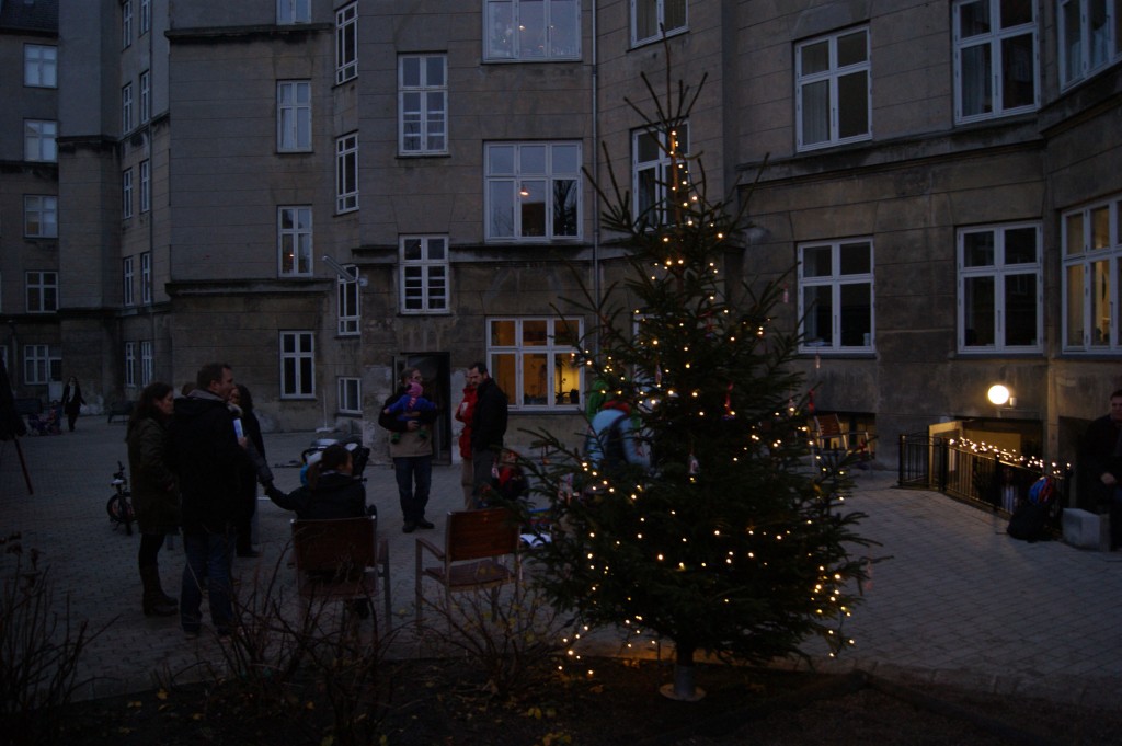 Folk snakker og hygger mens de kigger paa de smukke lys i juletraeet 2011