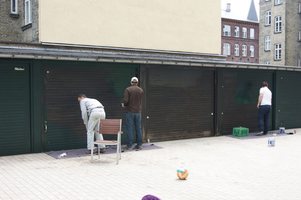 Tre af de frivillige er i gang med at male et lag Frederiksberg-grønne