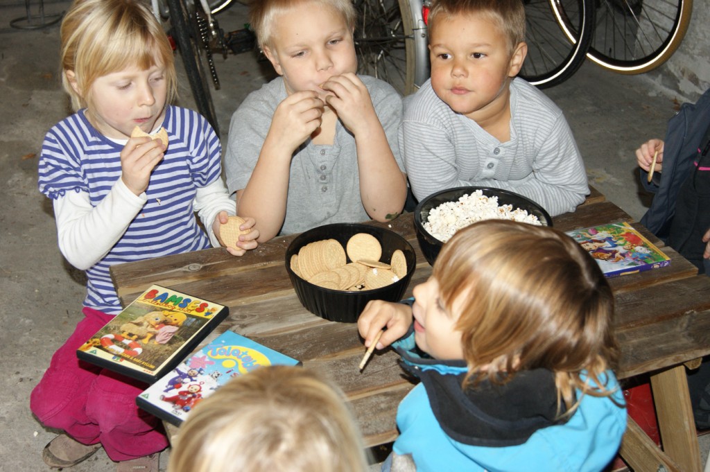 Børnene nyder småkager og popcorn i børnebiografen.