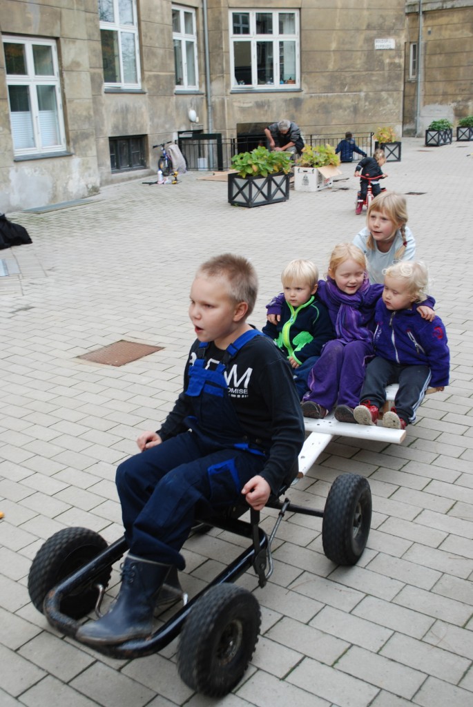 En dreng kører go-kart med 4 børn på slæb.